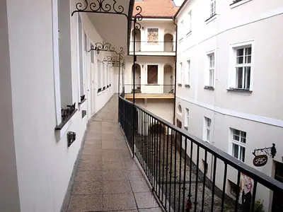 an empty corridor of a building with white walls and a balcony at Old Town Home Prague in Prague