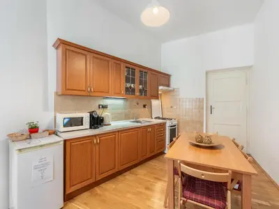 a kitchen with wooden cabinets and a wooden table at Old Town Home Prague in Prague