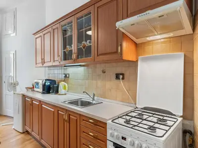 a kitchen with wooden cabinets and a white stove top oven at Old Town Home Prague in Prague