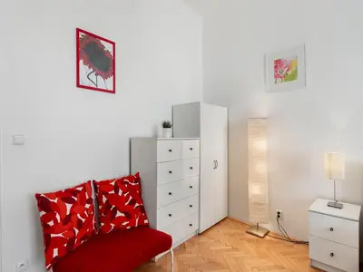 a bedroom with a red chair and a dresser at Old Town Home Prague in Prague