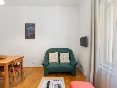 a living room with a green chair and a table at Old Town Home Prague in Prague