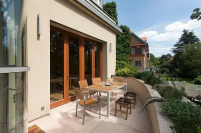 a patio with a table and chairs on a balcony at Huge luxury central Prague VILLA, 6 beds and baths, terraces, double garage in Prague