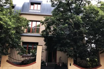 a building with a balcony and trees in front of it at Huge luxury central Prague VILLA, 6 beds and baths, terraces, double garage in Prague