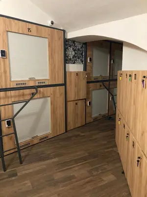 a room with wooden cabinets and a large window at Capsule Hostel Top Wenceslas square in Prague