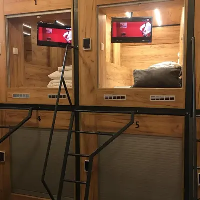 a tiny house with two windows and two televisions at Capsule Hostel Top Wenceslas square in Prague