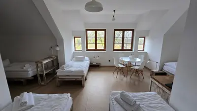 a room with two beds and a table and chairs at Dvůr Perlová voda in Budyně nad Ohří