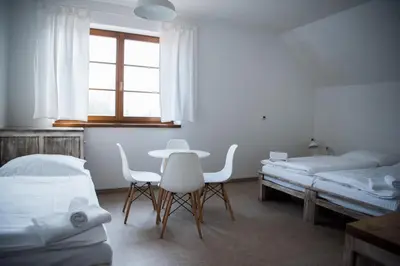 a room with two beds and a table and chairs at Dvůr Perlová voda in Budyně nad Ohří