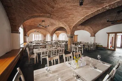 a dining room with tables and chairs in a building at Dvůr Perlová voda in Budyně nad Ohří