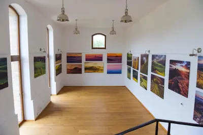 an art gallery with pictures on the walls at Dvůr Perlová voda in Budyně nad Ohří