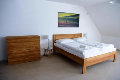 a bedroom with a wooden bed and a dresser at Dvůr Perlová voda in Budyně nad Ohří