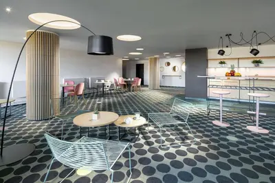 a lobby with chairs and tables and a kitchen at B&B Chuchle Arena Praha in Prague