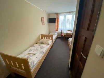 a small room with two beds and a window at Penzion Pod Zámkem in Pruhonice