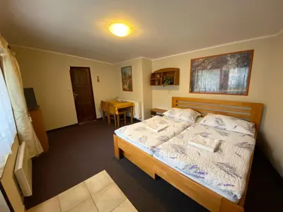 a bedroom with a bed and a table in it at Penzion Pod Zámkem in Pruhonice