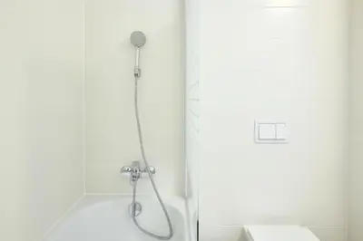 a shower with a shower head in a bathroom at Residence Port Karolina in Prague