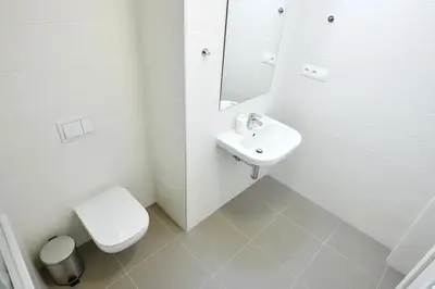 a white bathroom with a toilet and a sink at Residence Port Karolina in Prague