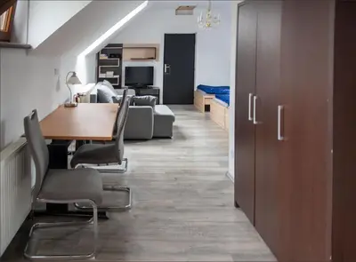 a dining room and living room with a table and chairs at V sadu in Lysá nad Labem