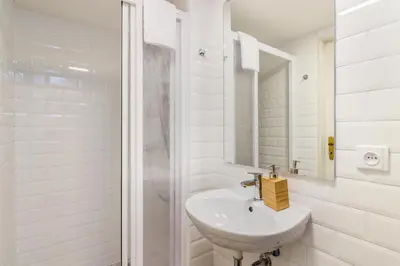 a white bathroom with a sink and a shower at Royal Apartments Prague by Michal&Friends in Prague
