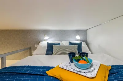 a tray with a bowl of fruit on a bed at Royal Apartments Prague by Michal&Friends in Prague