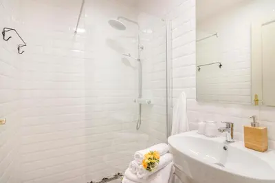 a white bathroom with a sink and a shower at Royal Apartments Prague by Michal&Friends in Prague
