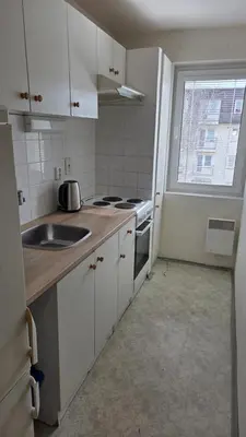 a kitchen with white cabinets and a sink and a window at Apartmán Mírová 472 B in Milovice
