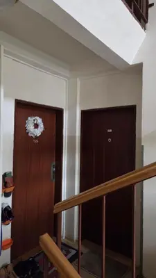 a hallway with a wooden door and a staircase at Apartmán Mírová 472 B in Milovice