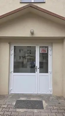 a garage with a white door with a sign on it at Apartmán Mírová 472 B in Milovice