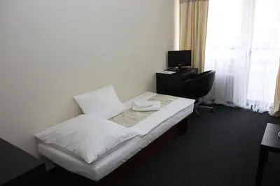 a hotel room with a bed and a desk at Hotel Kladno in Kladno