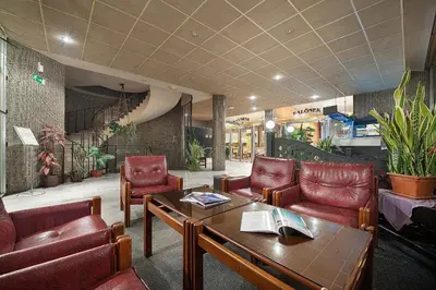 a lobby with red leather chairs and a table at Hotel Kladno in Kladno