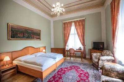 a bedroom with a bed and a living room at Vila Lanna in Prague