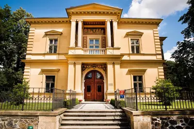 a large yellow house with a wooden door at Vila Lanna in Prague