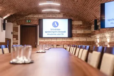 a long table in a room with chairs and a screen at Vila Lanna in Prague