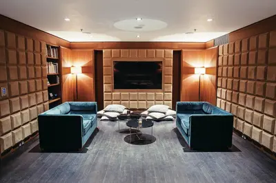 a living room with two couches and a tv at The Emblem Prague Hotel in Prague