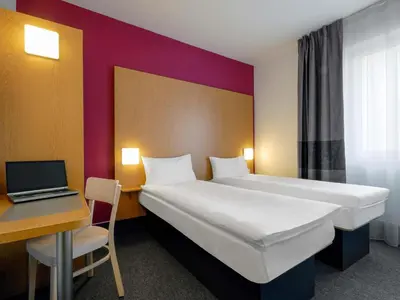 a hotel room with a bed and a desk and a laptop at B&B Hotel Prague City in Prague