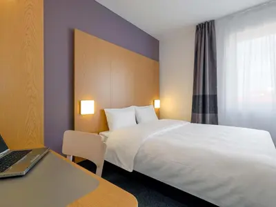 a hotel room with a bed and a laptop on a desk at B&B Hotel Prague City in Prague