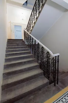 a staircase in a house with wrought iron railings at Modern apartment Spanelska in Prague