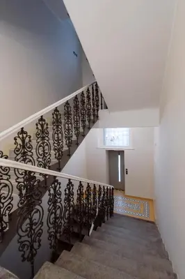 a staircase with a black wrought iron railing at Modern apartment Spanelska in Prague
