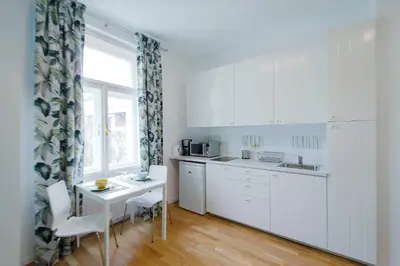 a kitchen with white cabinets and a table and a window at Modern apartment Spanelska in Prague