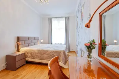 a bedroom with a bed and a table with a vase of flowers at Newly opened, designer OPERA Apartment in Prague
