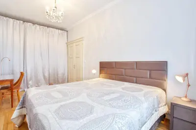 a bedroom with a large bed and a chandelier at Newly opened, designer OPERA Apartment in Prague