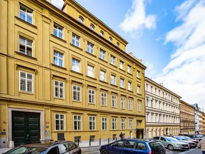 a yellow building with cars parked in front of it at Newly opened, designer OPERA Apartment in Prague