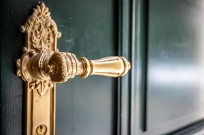 a gold door knob on a door with a mirror at Newly opened, designer OPERA Apartment in Prague