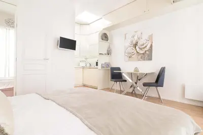 a white bedroom with a bed and a table and chairs at COZY&QUIET apartment with A/C in city centre in Prague