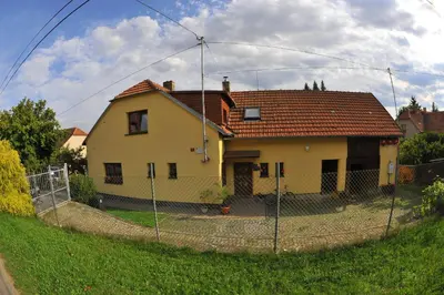 a house behind a fence in front of a house at Apartmá u Hovorků in Županovice