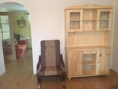 a living room with a chair and a cabinet at Apartmá u Hovorků in Županovice