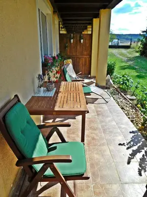 a patio with a wooden table and chairs on a porch at Studio Boroví in Karlštejn