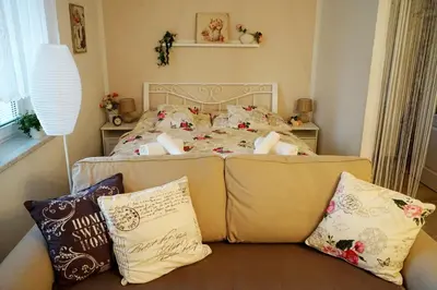a bedroom with a bed and a couch with pillows at Studio Boroví in Karlštejn