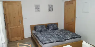 a bedroom with a bed and two wooden cabinets at Ubytování Na Vyhlídce 143 in Benátky nad Jizerou