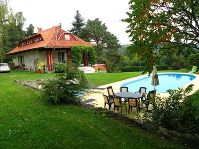a house with a table and chairs next to a pool at Villa Blanka in Horní Podkozí