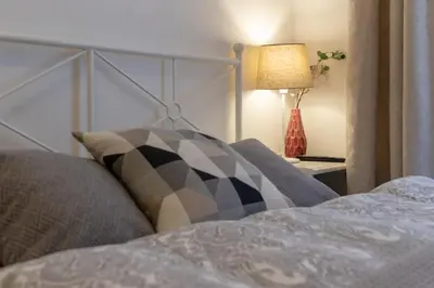 a bed with a pillow and a lamp on a table at Awesome Stay Studios in Prague