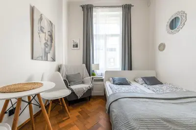 a bedroom with two beds and a table and a chair at Awesome Stay Studios in Prague